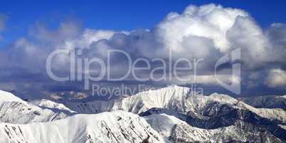 Panoramic view on snowy ridges in sun winter day