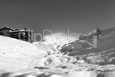 Black and white view on off-piste slope and hotel in winter moun