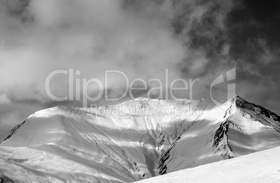 Black and white view on off-piste snowy slope in wind day