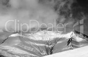 Black and white view on off-piste snowy slope in wind day