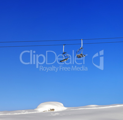 Chair-lift and blue clear sky at sunny day