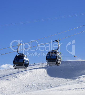 Gondola lift on ski resort at windy sun day