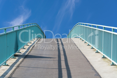 Fußgänger Brücke aus Stahl in Bogenkunstruktion über den Flu