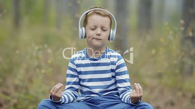 Cute Little Boy Meditating In The Forest