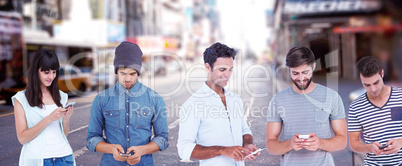 Composite image of handsome man text messaging through smart phone