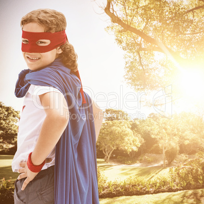 Composite image of side view of boy in cape and mask