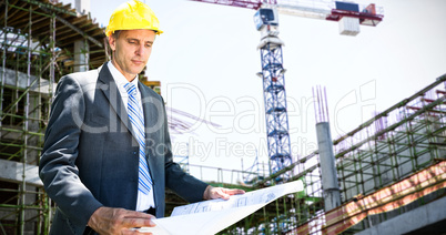 Composite image of architect holding blueprint