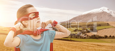 Composite image of cute girl in eye mask and cape