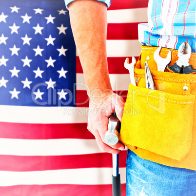 Composite image of handyman wearing tool belt while holding hammer