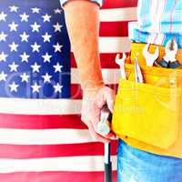 Composite image of handyman wearing tool belt while holding hammer