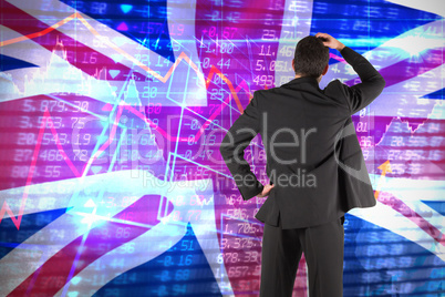 Composite image of businessman standing back to the camera with hand on head