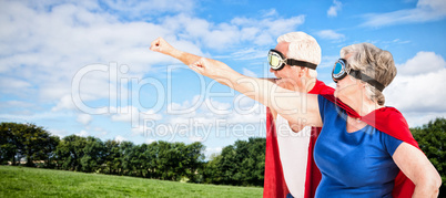 Composite image of senior couple wearing superman costume