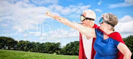 Composite image of senior couple wearing superman costume