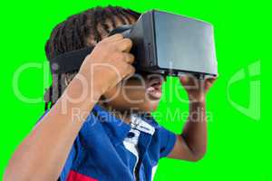 Composite image of profile view of little boy holding virtual glasses