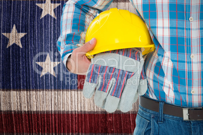 Composite image of construction worker holding hard hat and gloves