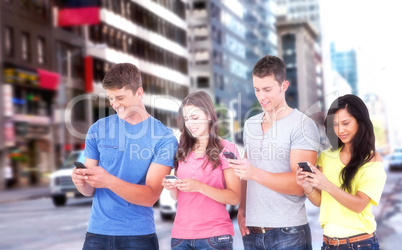 Composite image of four friends standing to the side slightly sending texts