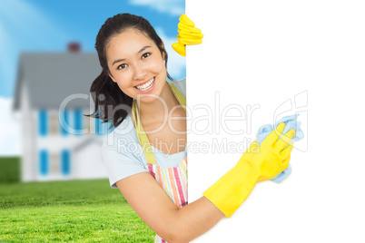 Composite image of cheerful woman cleaning white surface