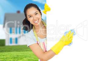 Composite image of cheerful woman cleaning white surface