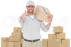 Composite image of delivery man with cardboard box gesturing thumbs up