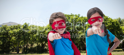 Composite image of portrait of cute siblings with red cap and mask