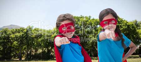 Composite image of portrait of cute siblings with red cap and mask