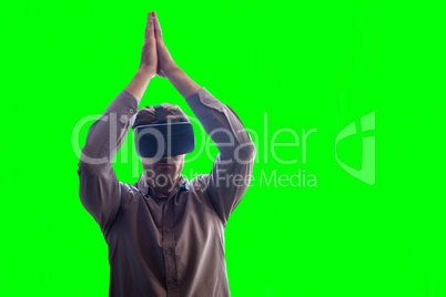 Composite image of man wearing virtual reality headset while standing