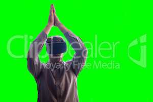 Composite image of man wearing virtual reality headset while standing