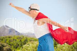 Composite image of senior man wearing superman costume