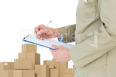 Composite image of delivery man writing on clipboard