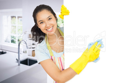 Composite image of cheerful woman cleaning white surface