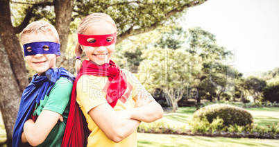 Composite image of happy brother and sister in cape and eye mask