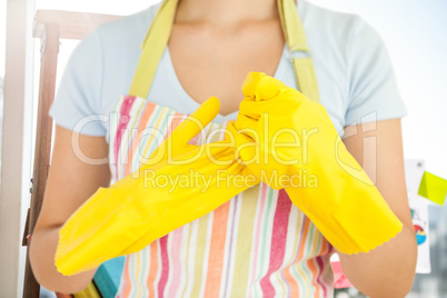 Composite image of woman taking off her rubber gloves