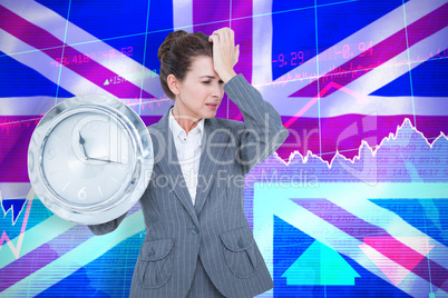 Composite image of upset businesswoman holding wall clock