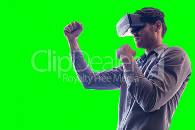 Composite image of man wearing virtual reality headset while boxing