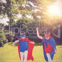 Composite image of masked kids walking pretending to be superheroes