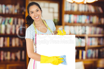 Composite image of cheerful woman wiping down white surface