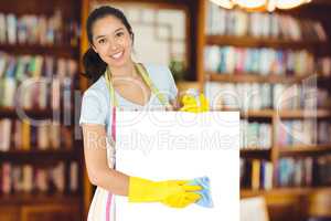 Composite image of cheerful woman wiping down white surface