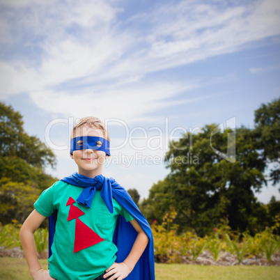 Composite image of portrait of boy in blue eye mask and cape