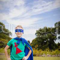 Composite image of portrait of boy in blue eye mask and cape