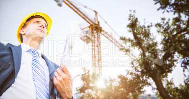 Composite image of low angle view of architect holding blueprint