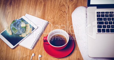 Composite image of overhead shot of laptop, tablet, coffee and headphones