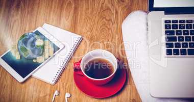 Composite image of overhead shot of laptop, tablet, coffee and headphones