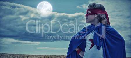 Composite image of boy wearing superhero costume
