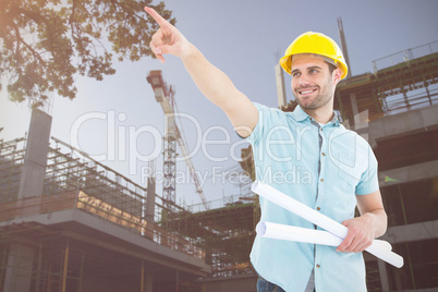 Composite image of male architect with blueprints pointing away