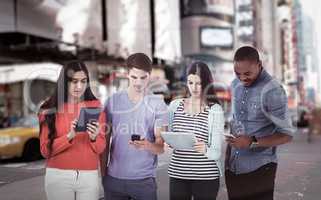 Composite image of young creative team looking at phones and tablets