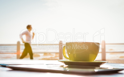 Composite image of sporty woman jogging at promenade