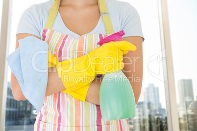 Composite image of woman holding window cleaner and rag