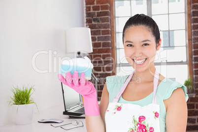 Composite image of smiling woman holding a sponge