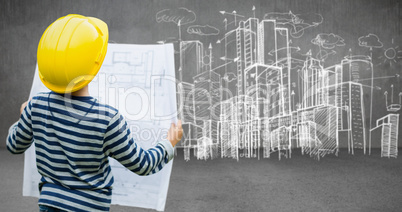 Composite image of boy in hard hat reading a plan