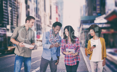 Composite image of four stylish friends looking at tablet and holding phones